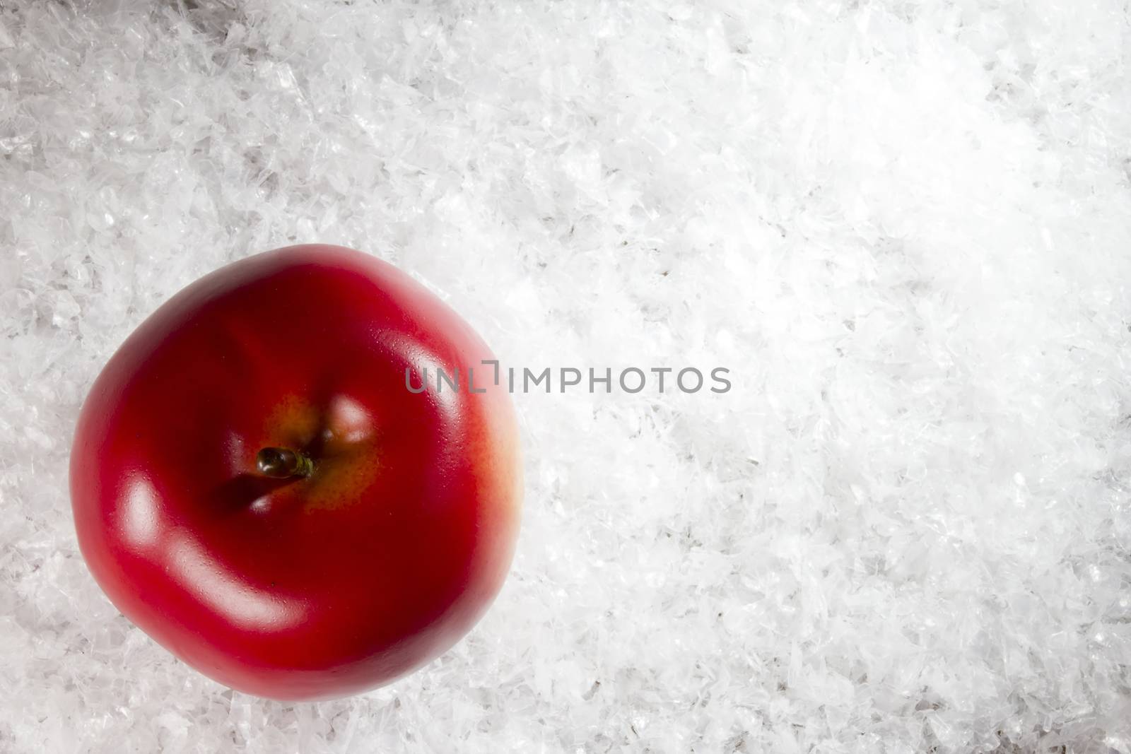 Red apple on white freshly fallen snow