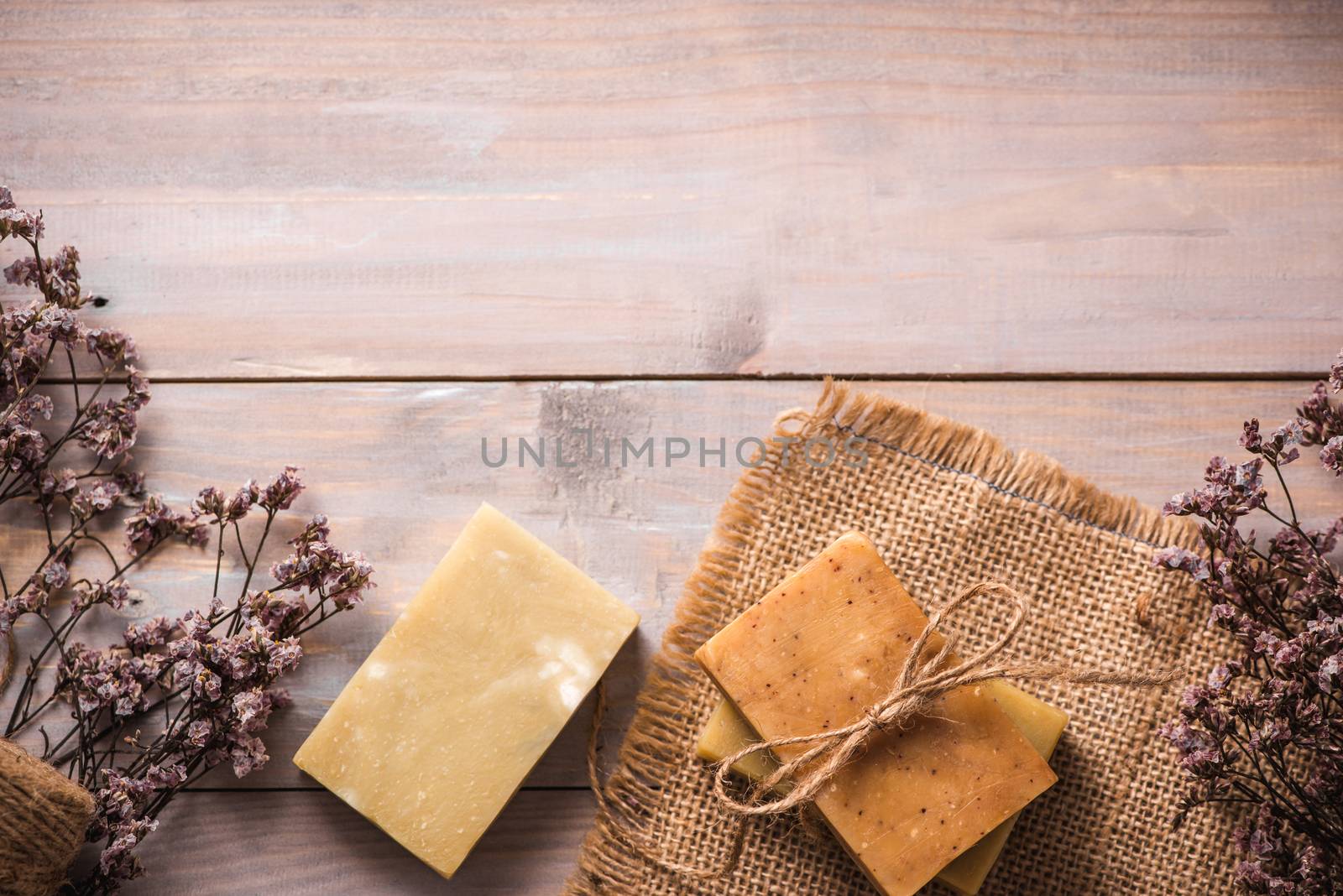 Natural soap with dried flowers on wooden background. by makidotvn