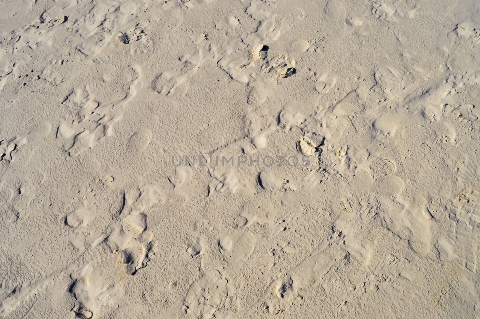 Mark of feet in the white sand of a beach near Mombasa in Kenya