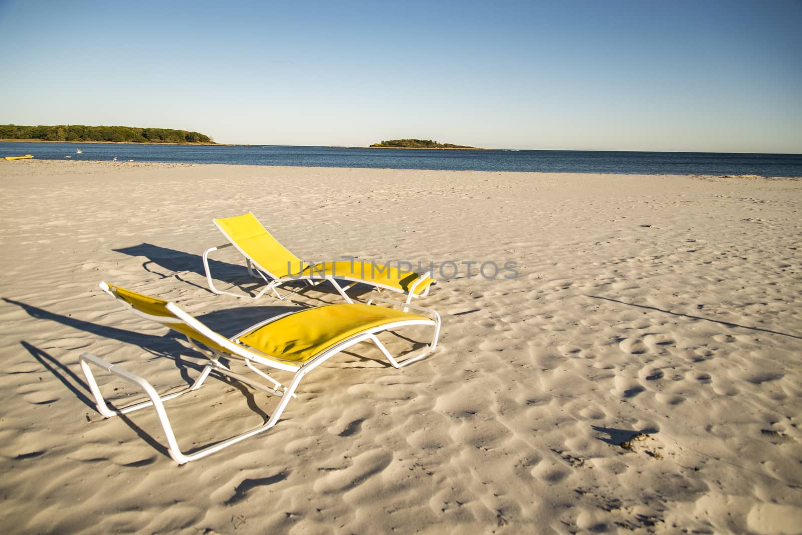 Two deck chairs on sandy beach in Maine, USA