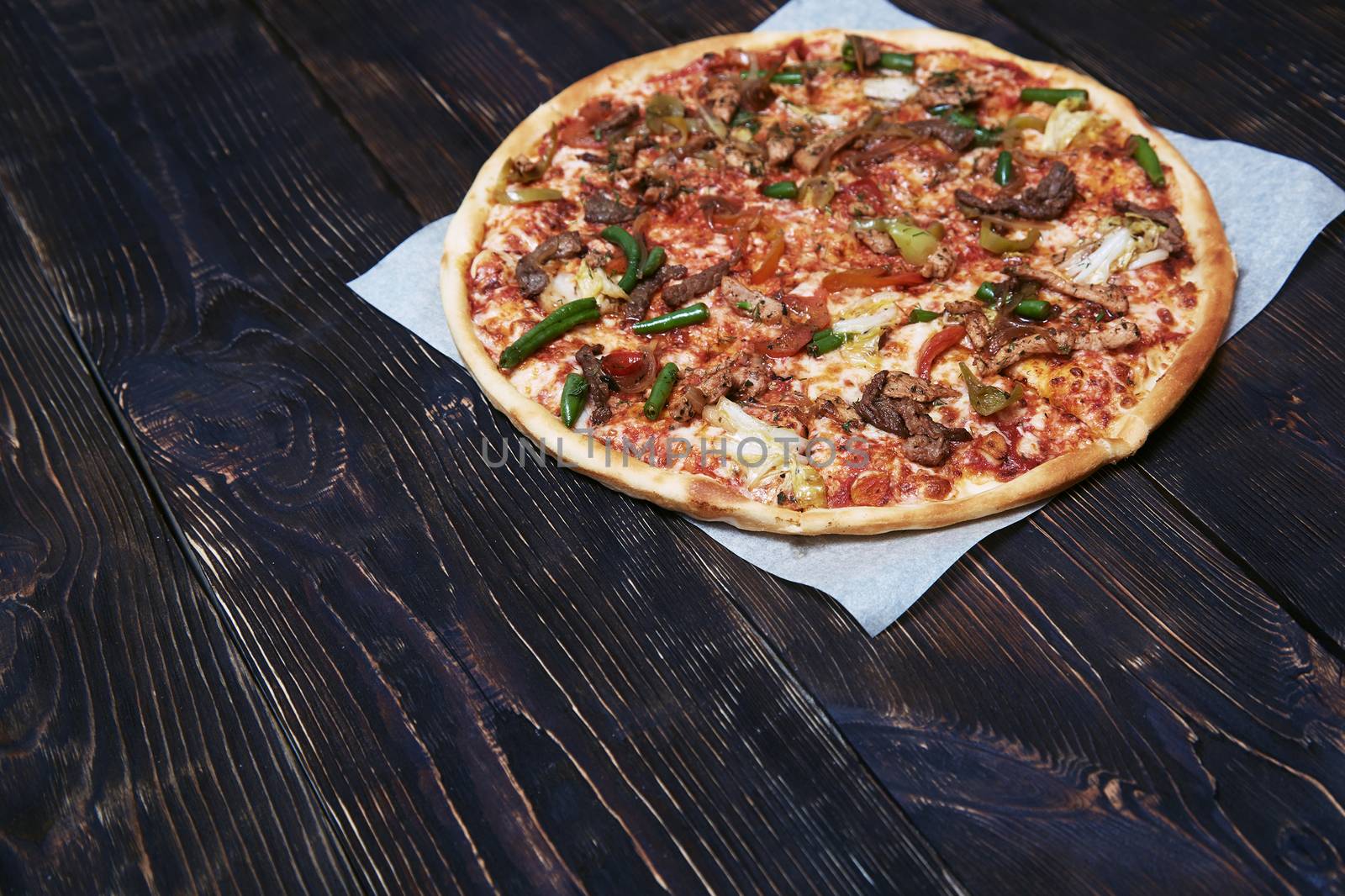 Homemade pizza on a wooden table by Novic