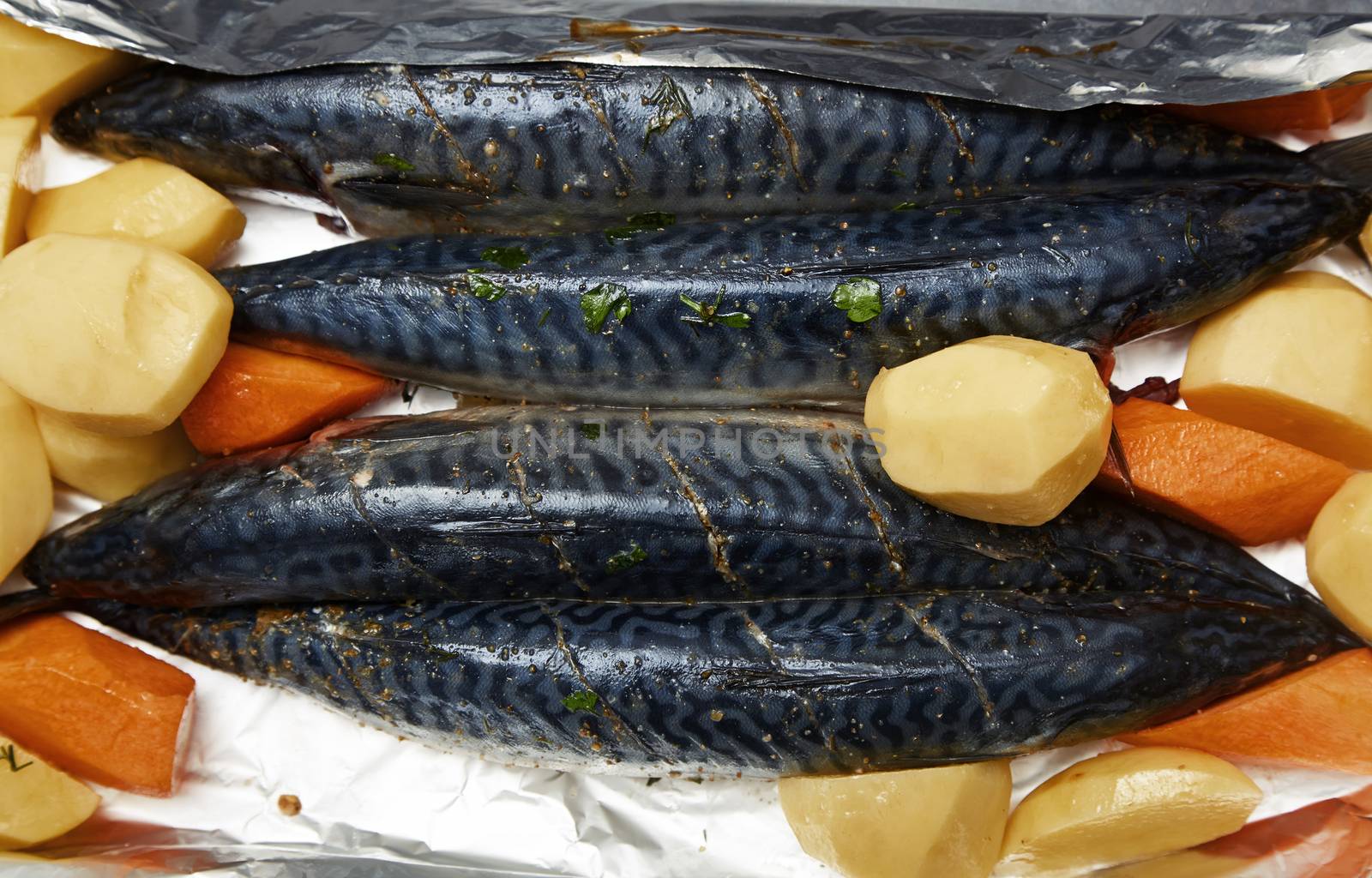 Fish with potato and carrot ready to be cooked