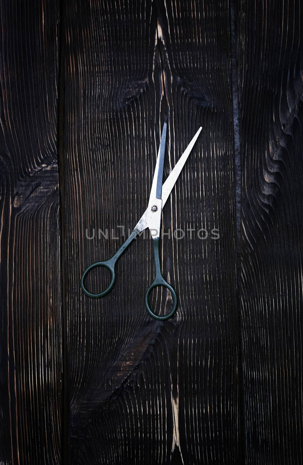 Scissors on a wooden table background