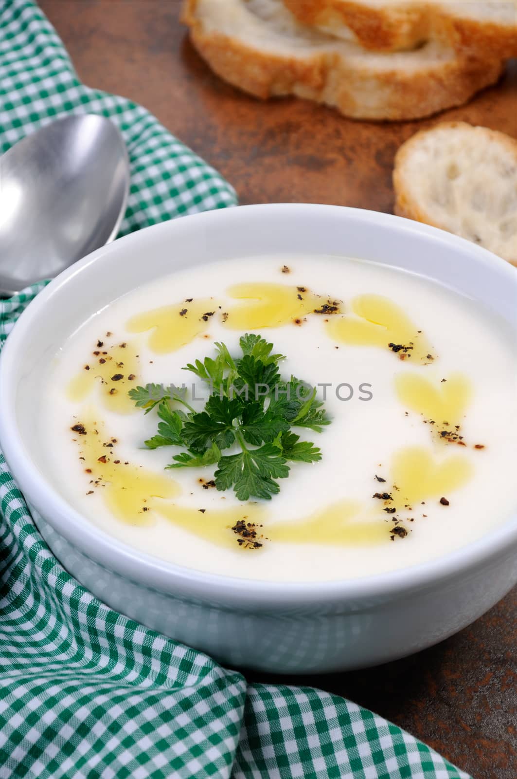 A bowl of white bean puree soup with spicy butter and spices, herb