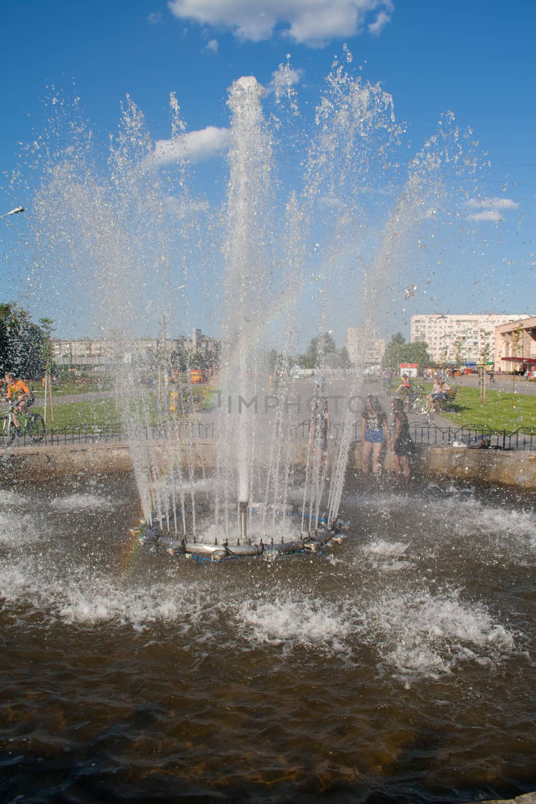 Rainbow in fountain splashes in the park