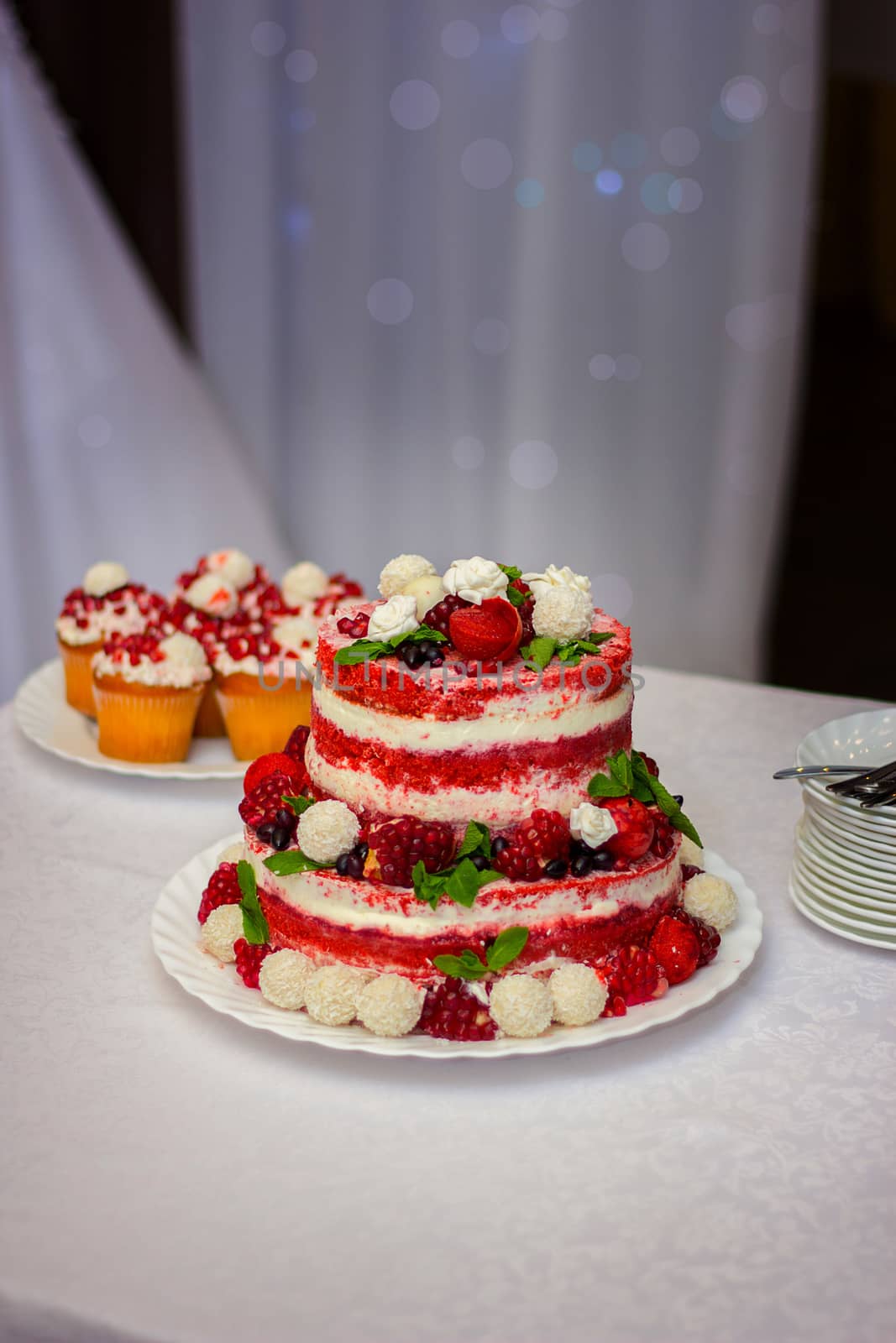 wedding cake on a table with a wild strawberry and berries