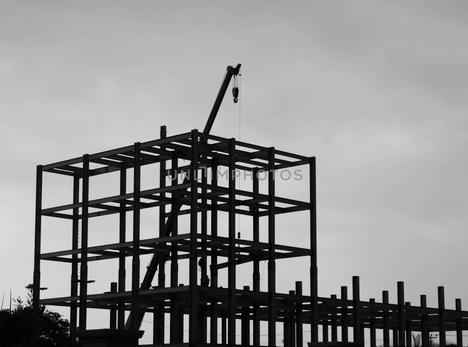 BLACK AND WHITE PHOTO OF SILHOUETTE CONSTRUCTION CRANE