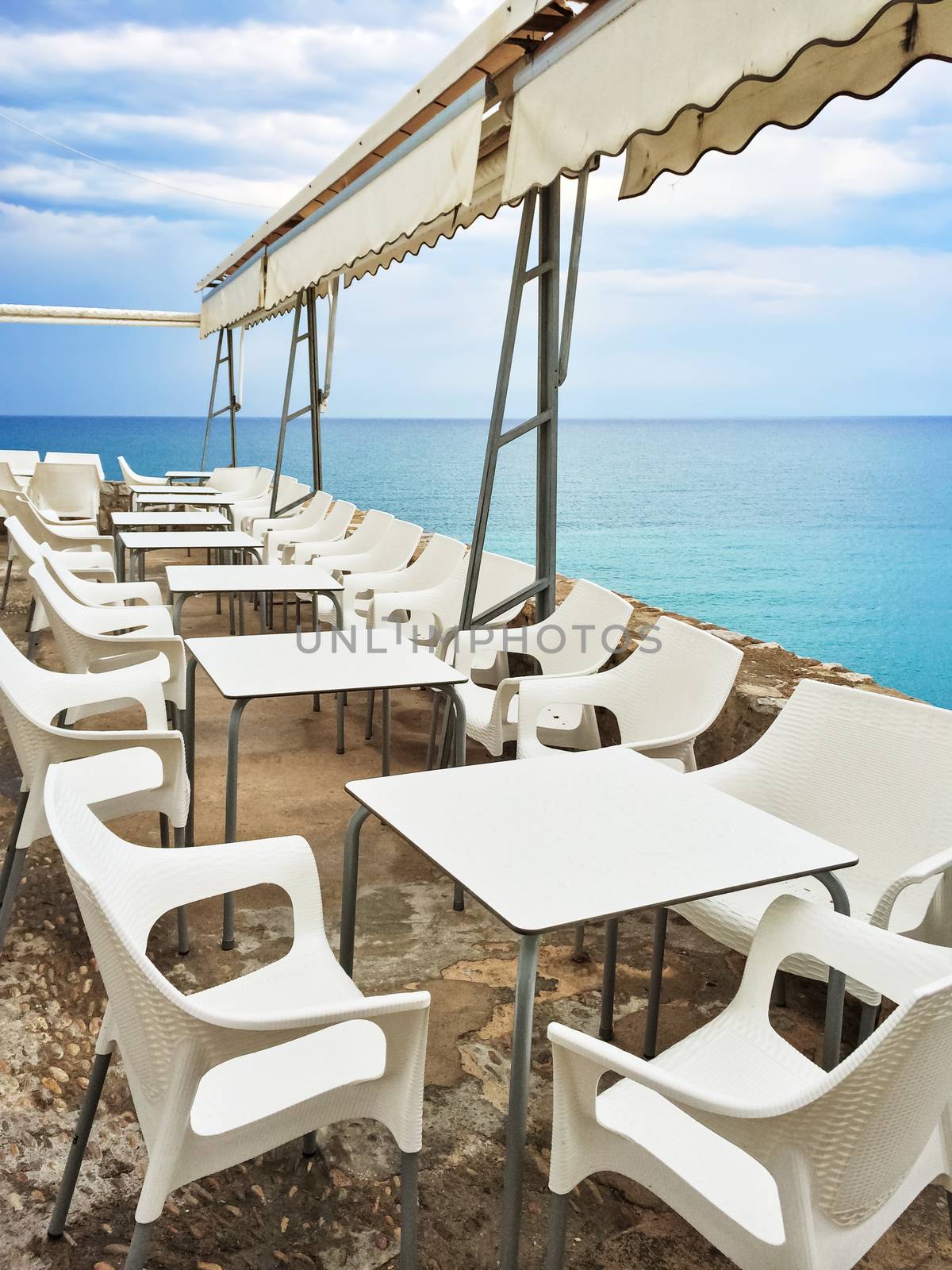 White tables in a cafe by the seaside. Peniscola, resort in the province of Castellon, Valencian Community, Spain.