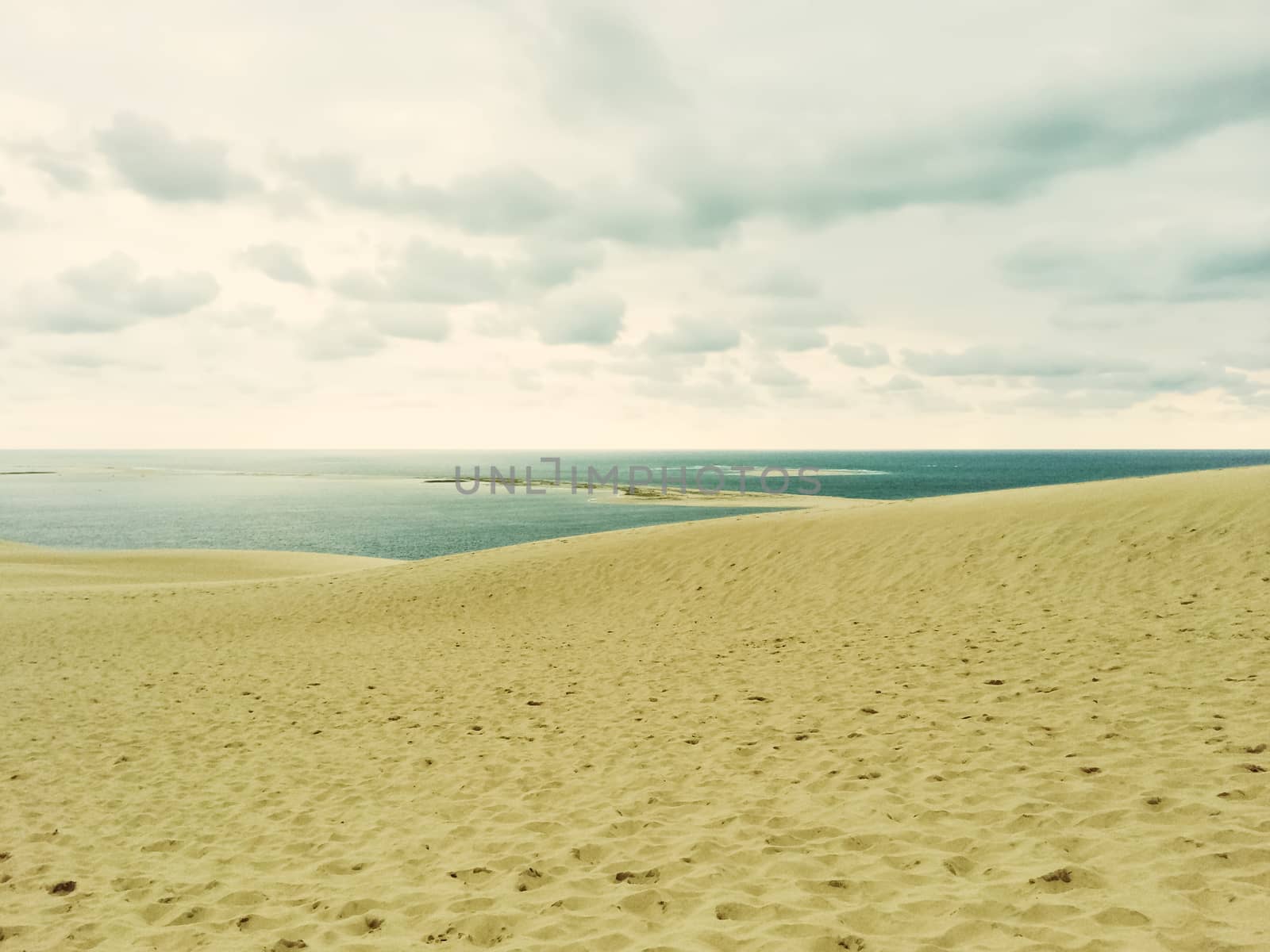 Sand dunes, sea and cloudy sky. Dune of Pilat (Dune du Pilat), the biggest sand dune in Europe, located in the Arcachon Bay area, France.