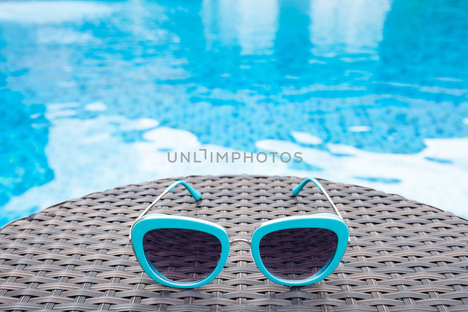 Summertime sunglasses relax near swimming pool.