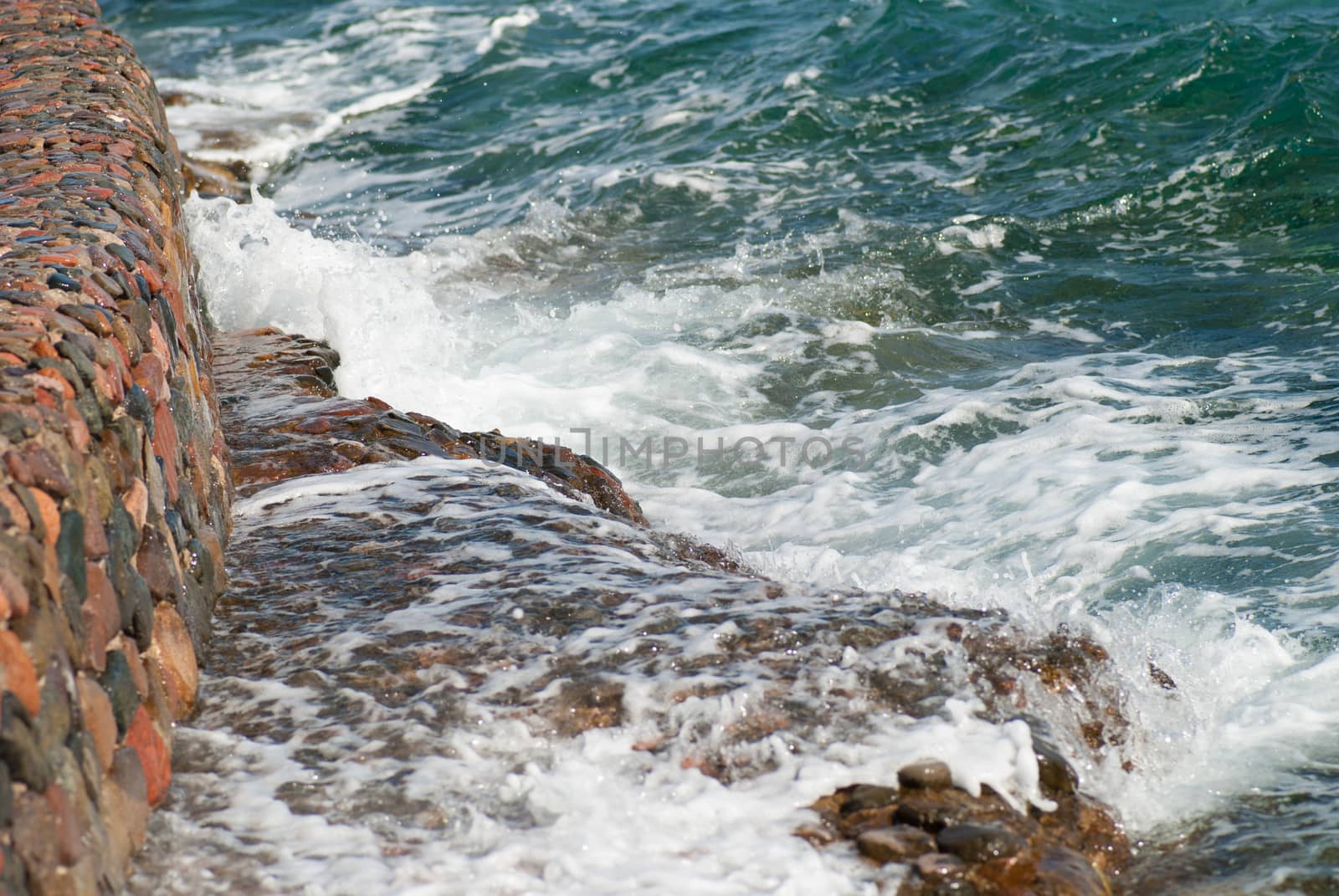 Photo of beautiful clear turquoise sea ocean water surface with ripples and bright splash on stone seascape background, horizontal picture by skrotov