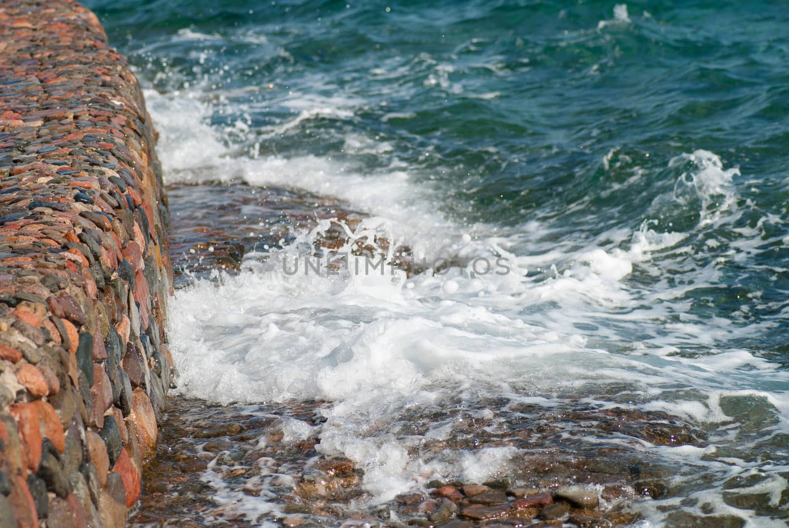 Photo of beautiful clear turquoise sea ocean water surface with ripples and bright splash on stone seascape background, horizontal picture by skrotov