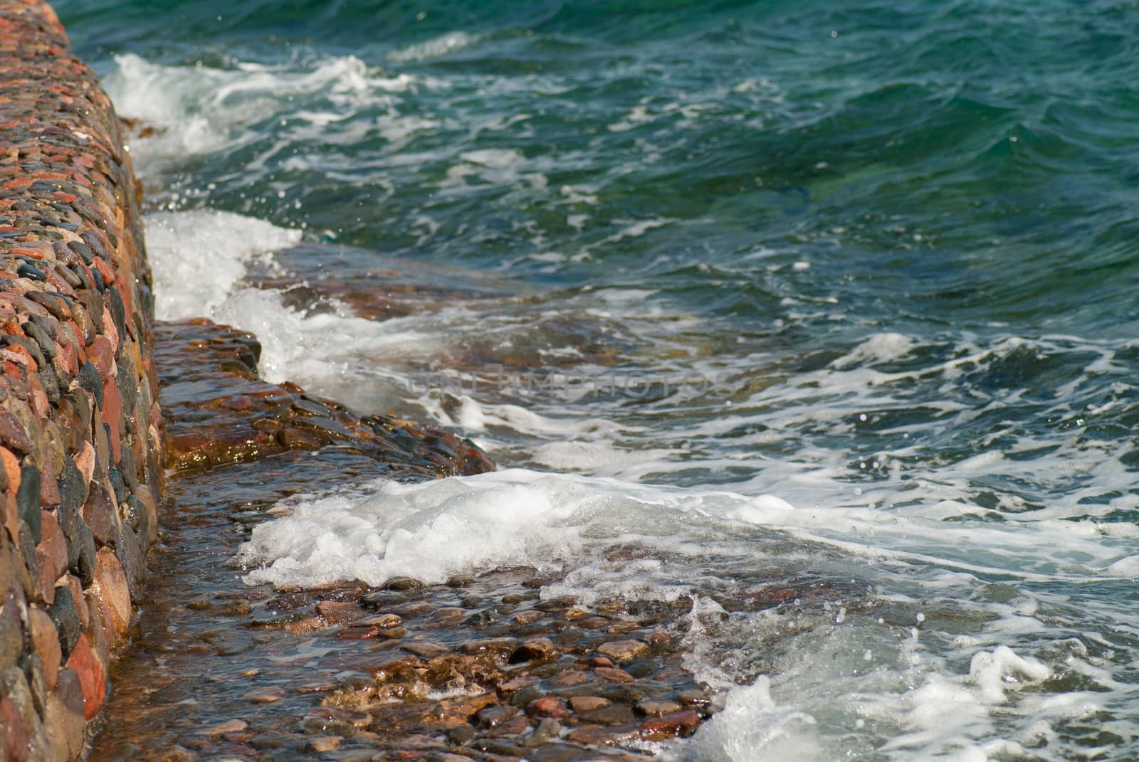 Photo of beautiful clear turquoise sea ocean water surface with ripples and bright splash on stone seascape background, horizontal picture by skrotov