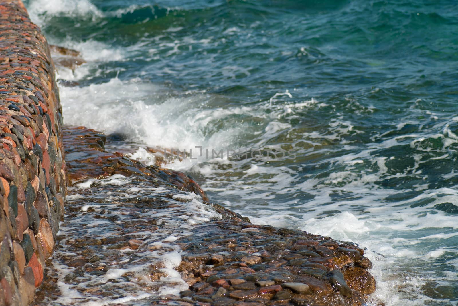 Photo of beautiful clear turquoise sea ocean water surface with ripples and bright splash on stone seascape background, horizontal picture by skrotov