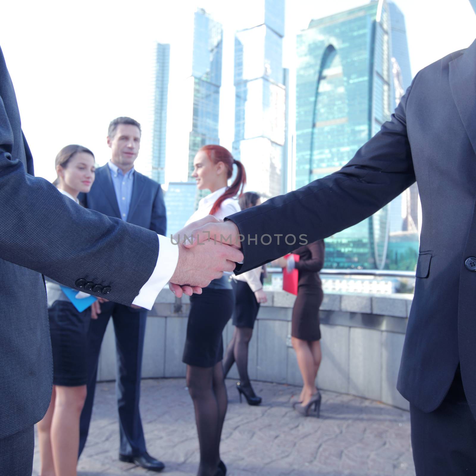 Business handshake, the deal Is finalized by group of people outside