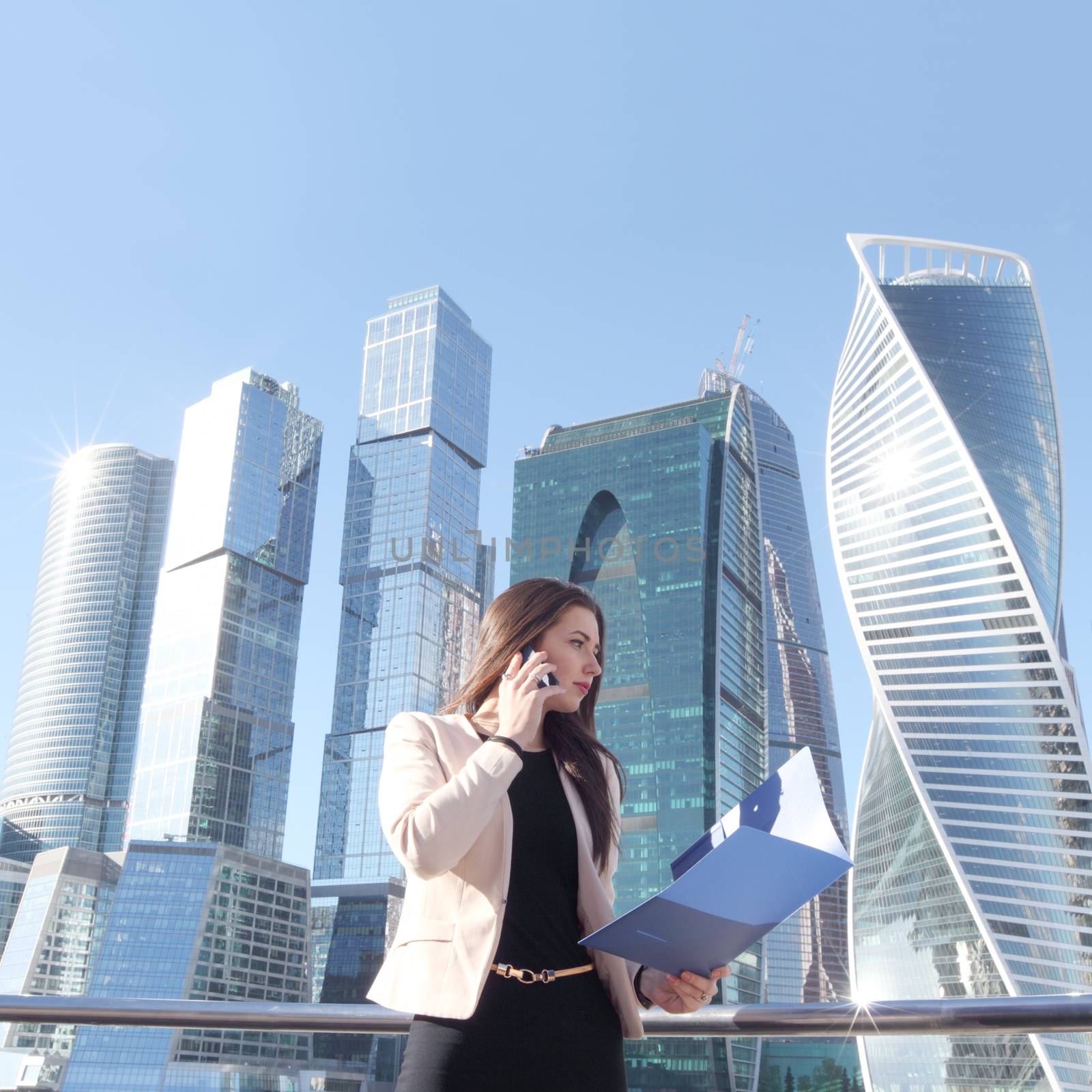 Businesswoman at skyscraper background by ALotOfPeople