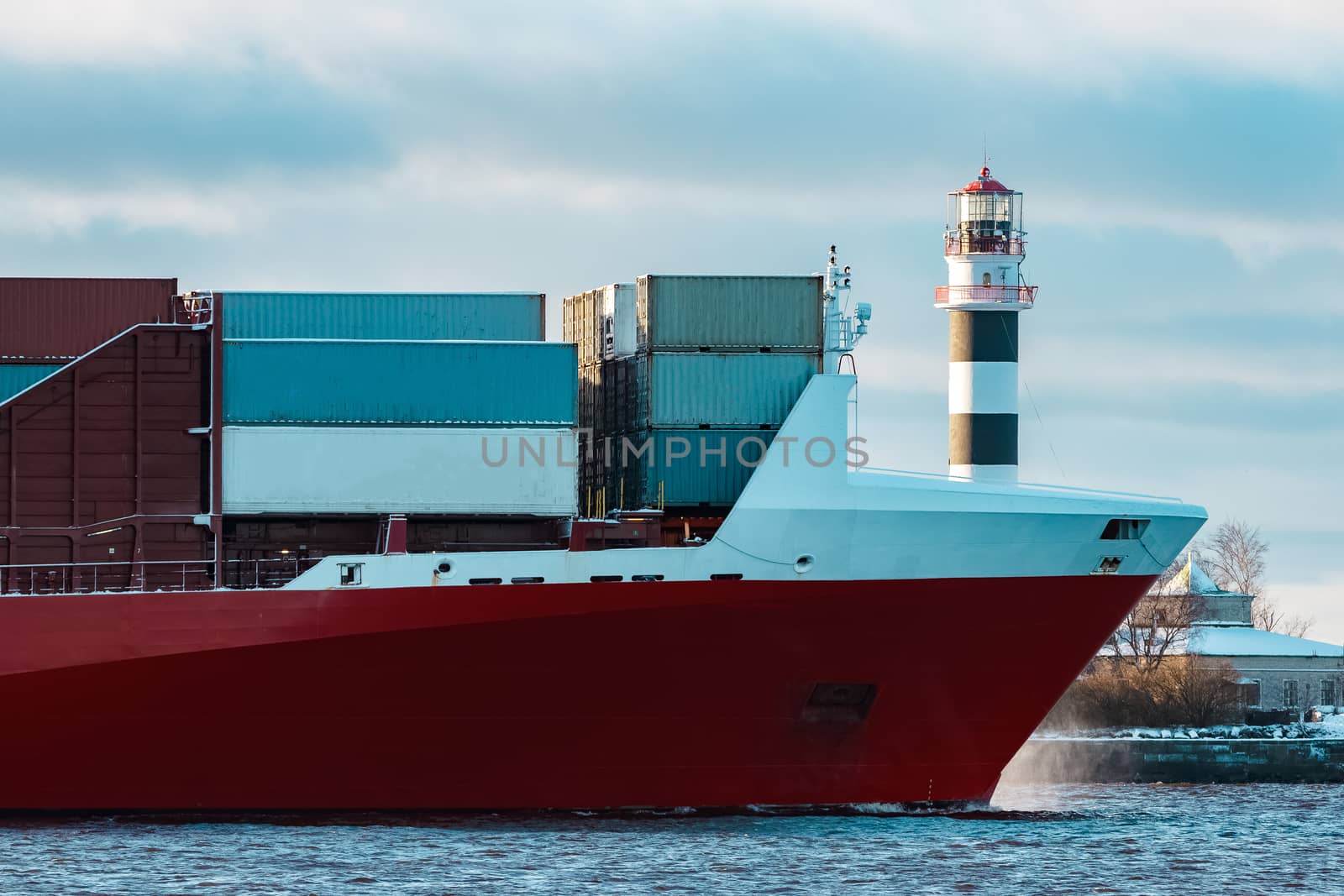 Full red container ship moving in still water