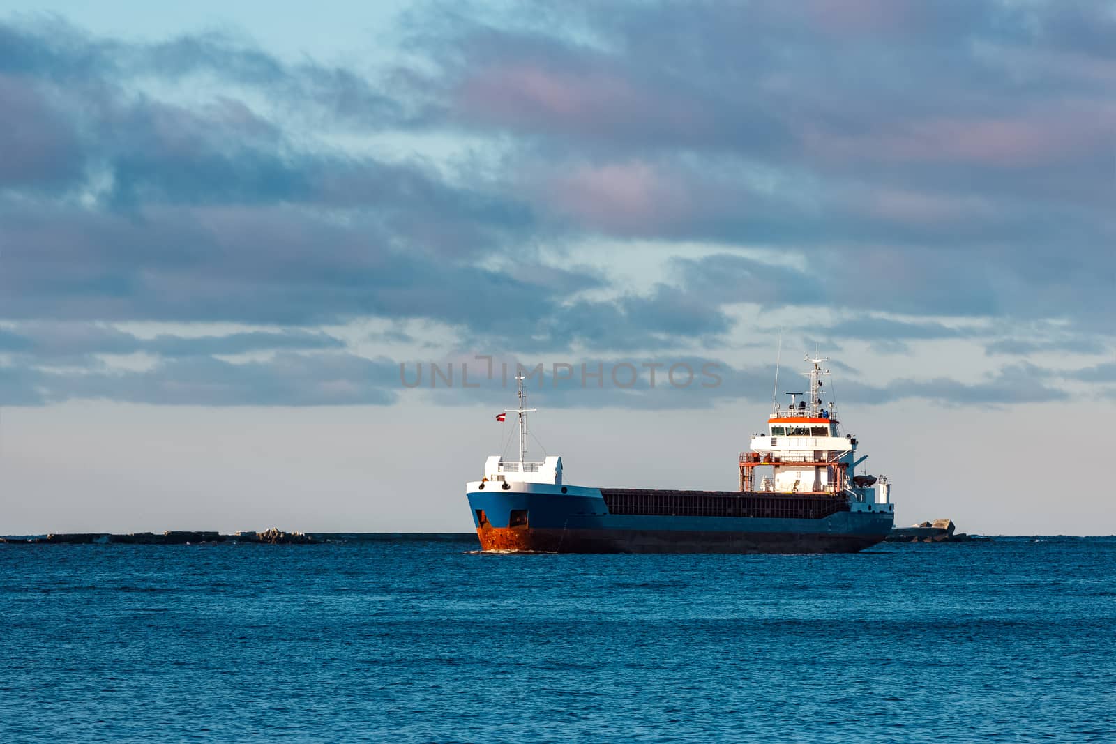Blue bulk carrier sailing in still water