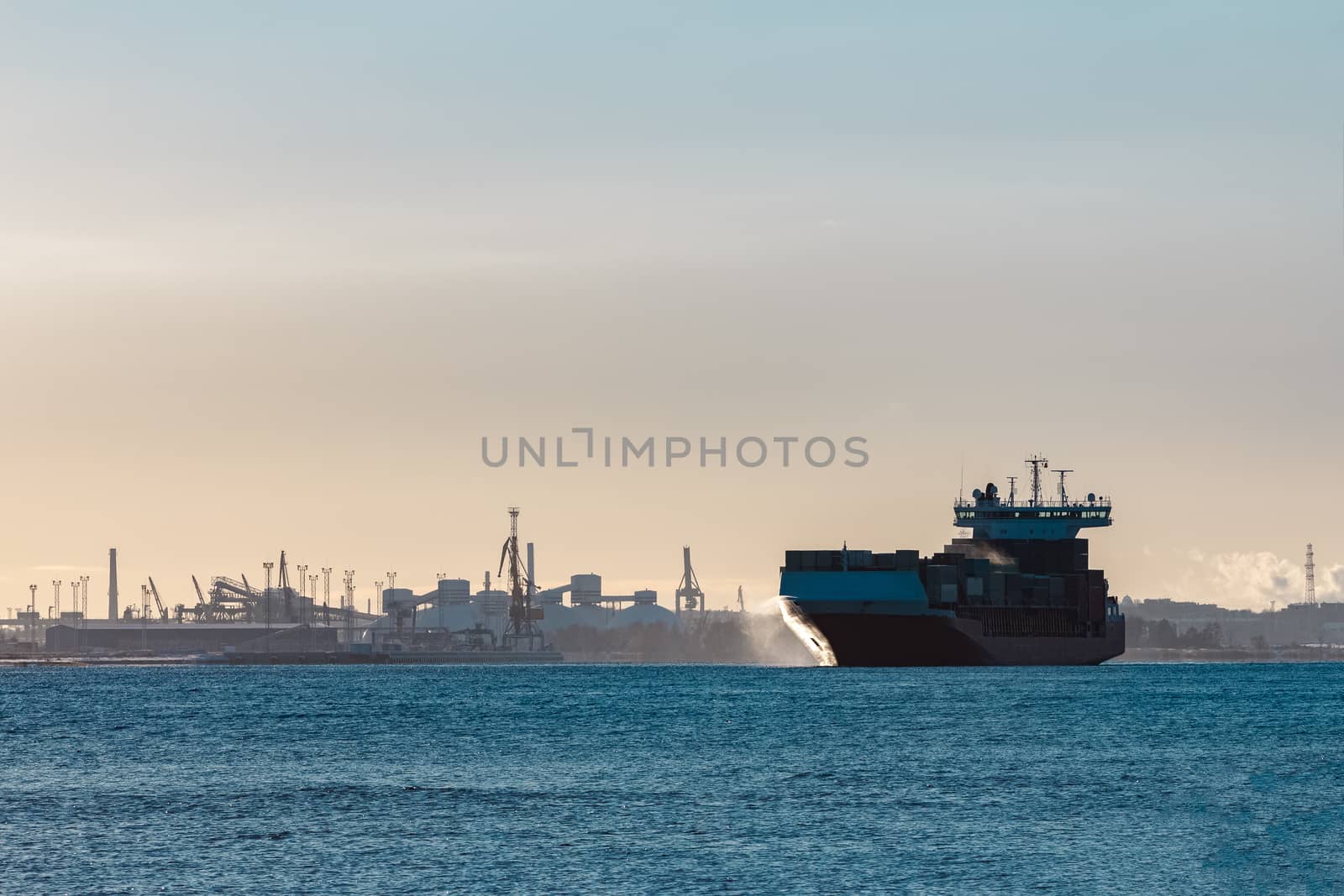 Full red container ship moving in still water