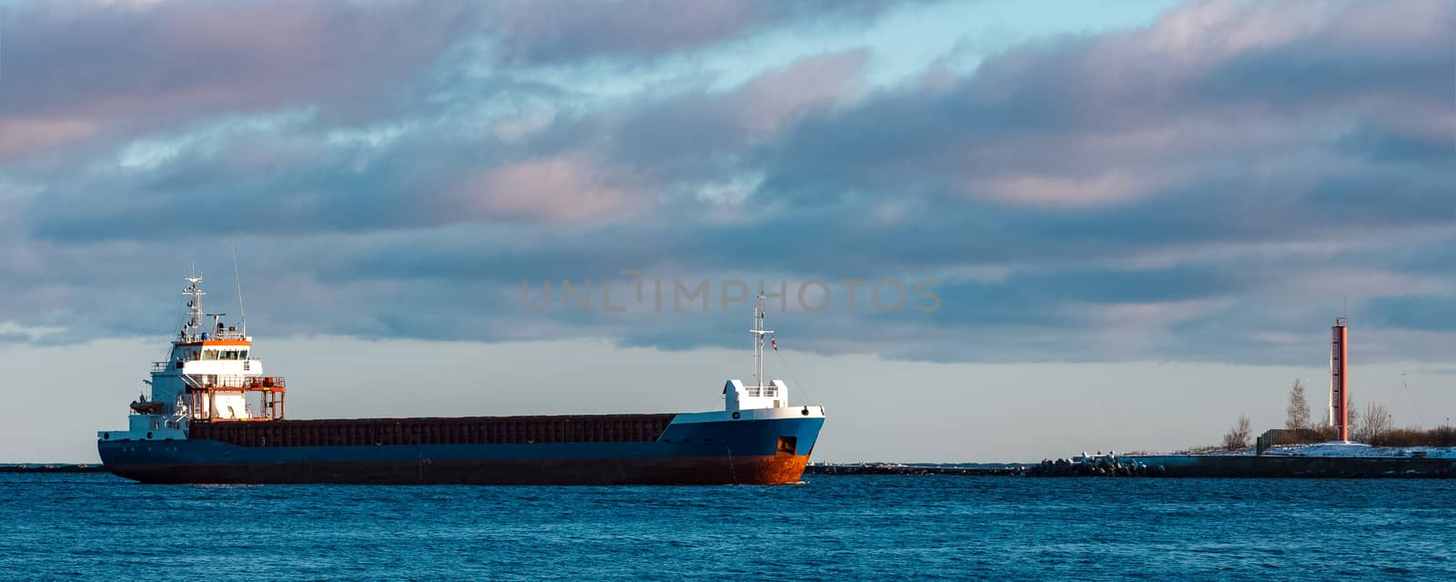 Blue bulk carrier sailing in still water