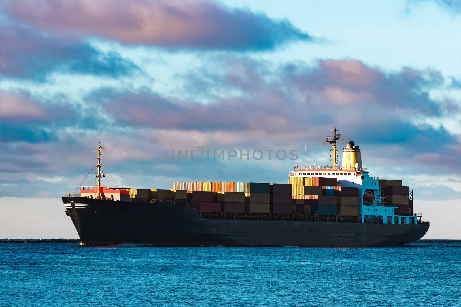 Modern black container ship moving from Baltic sea