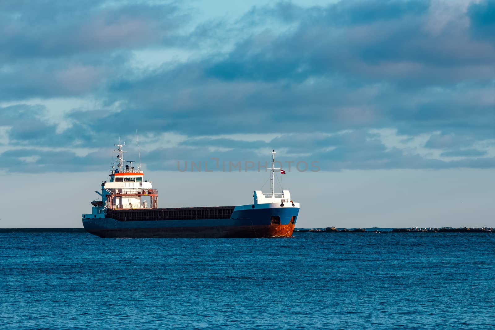 Blue bulk carrier sailing in still water