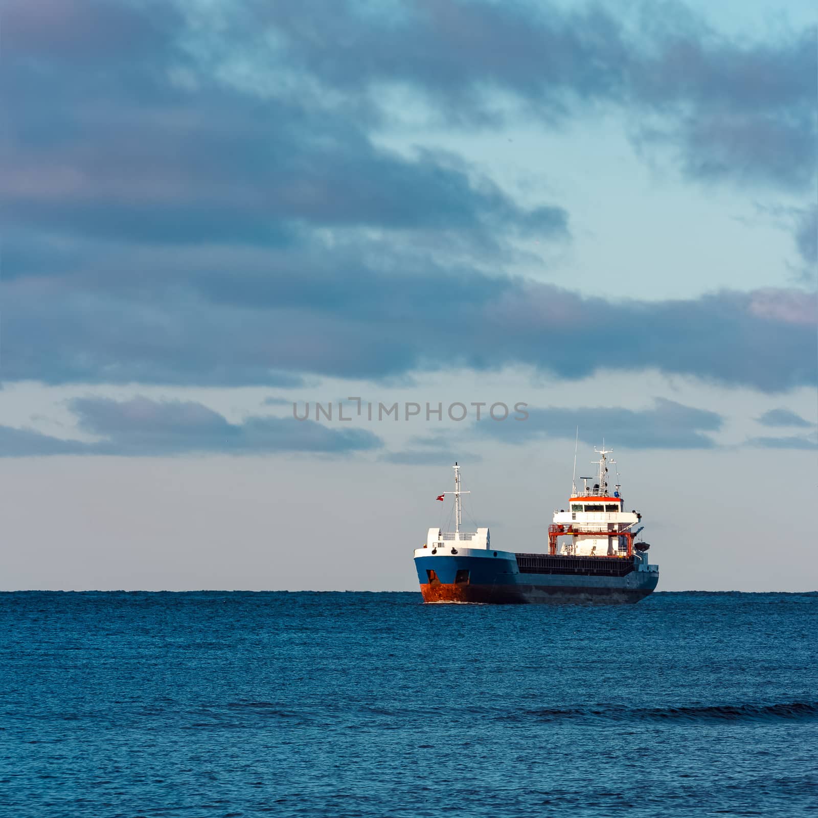 Blue bulk carrier sailing in still water