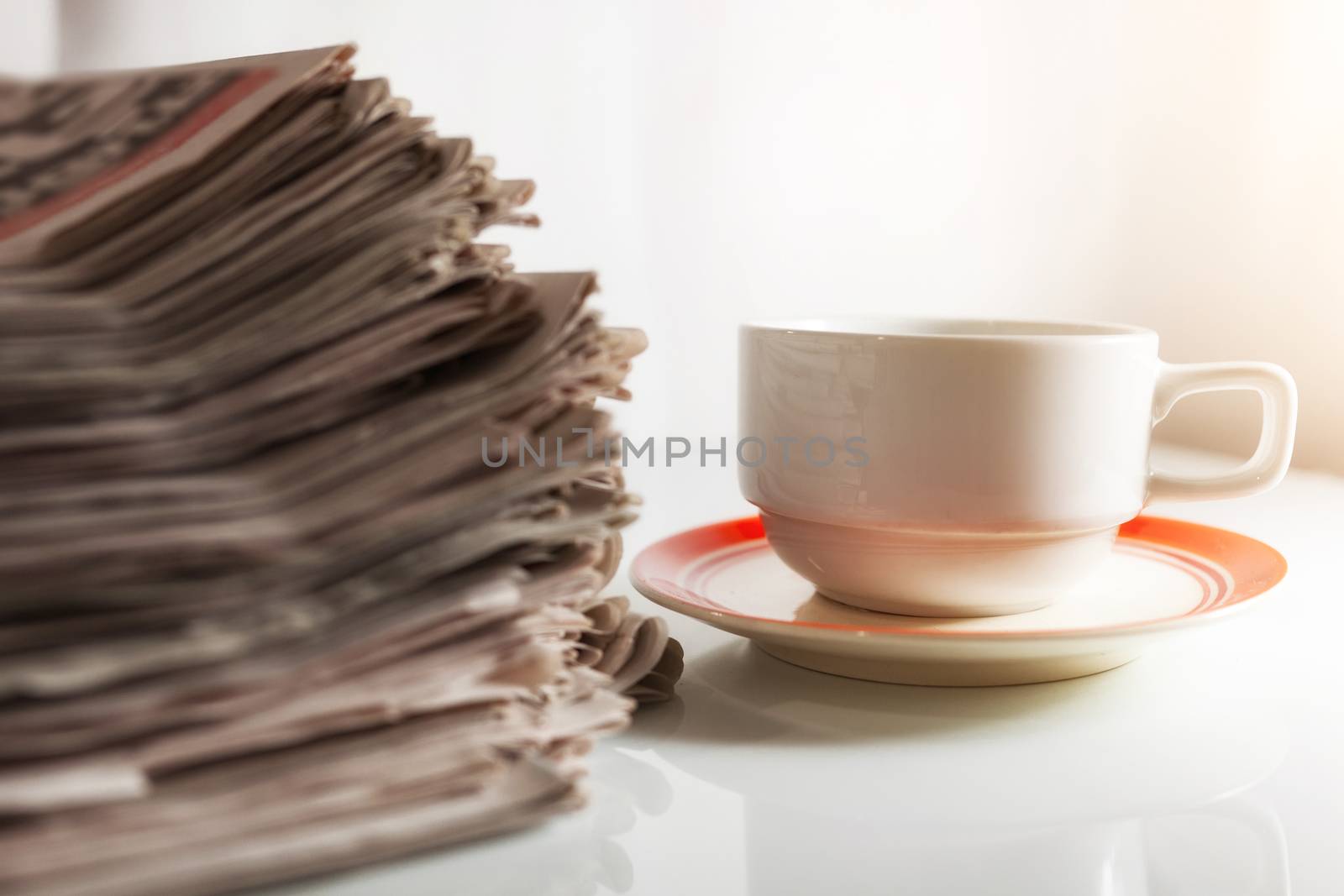 Newspapers and Coffee on the white table .