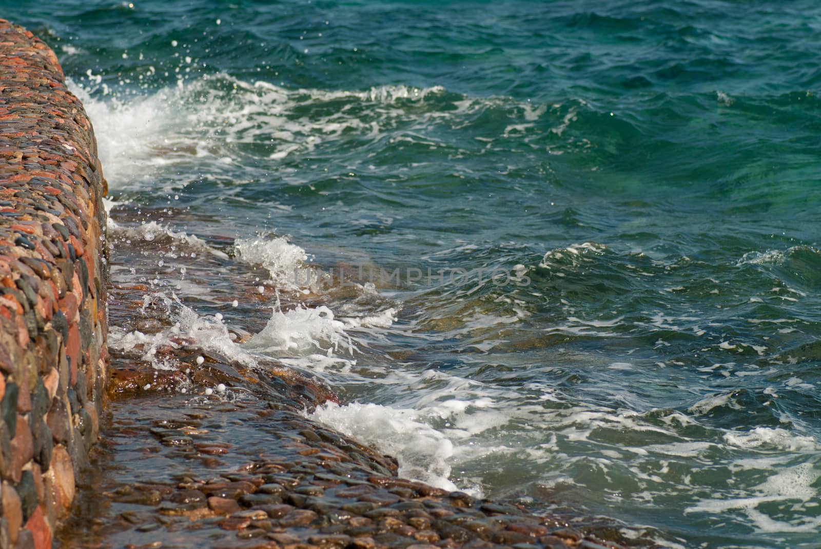 Photo of beautiful clear turquoise sea ocean water surface with ripples and bright splash on stone seascape background, horizontal picture by skrotov