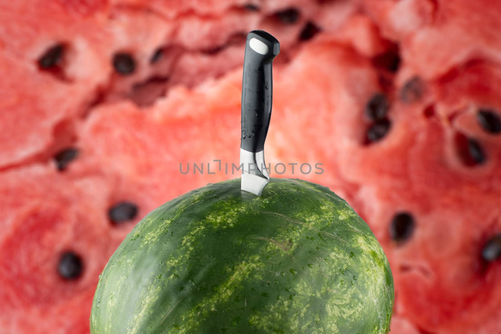 Riped watermelon with knife and red meat background by skrotov