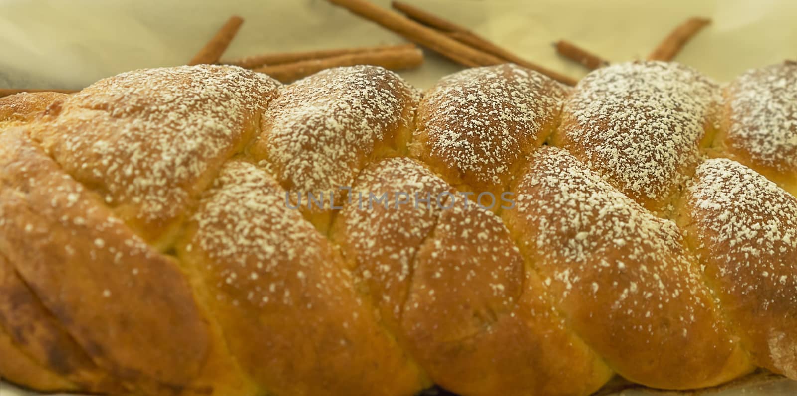 Fresh baked food delight, a crusty braided cinnamon bread twist dusted with icing sugar 