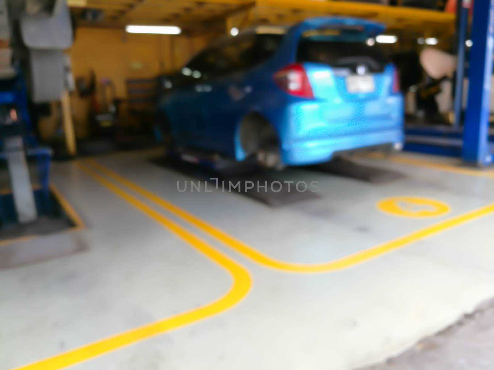 Blurred background of technician repairing the car in garage by ahimaone