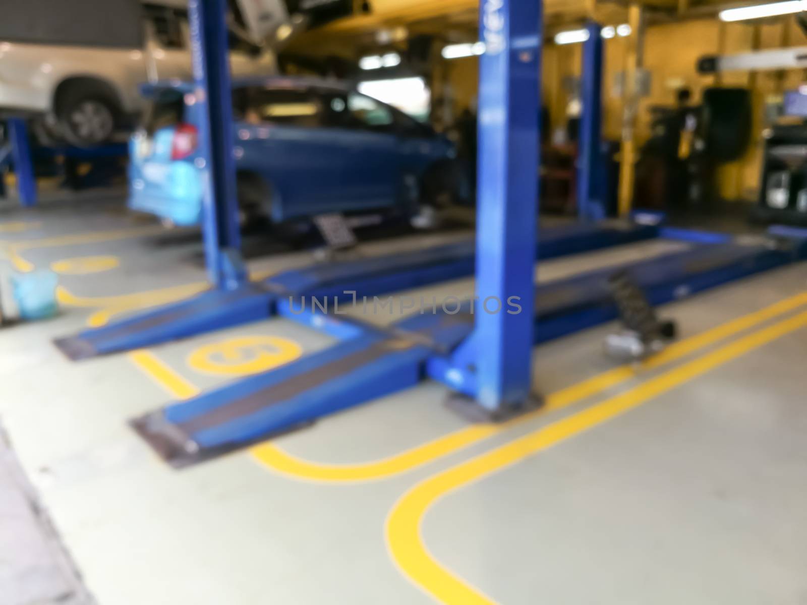 Blurred background of technician repairing the car in garage