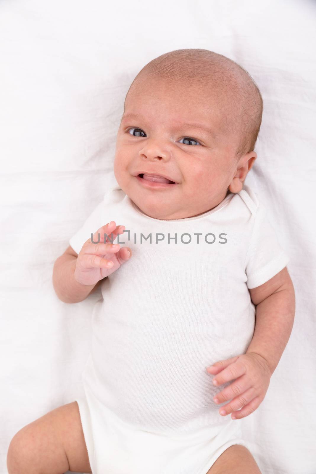 Newborn baby on white sheet by dutourdumonde