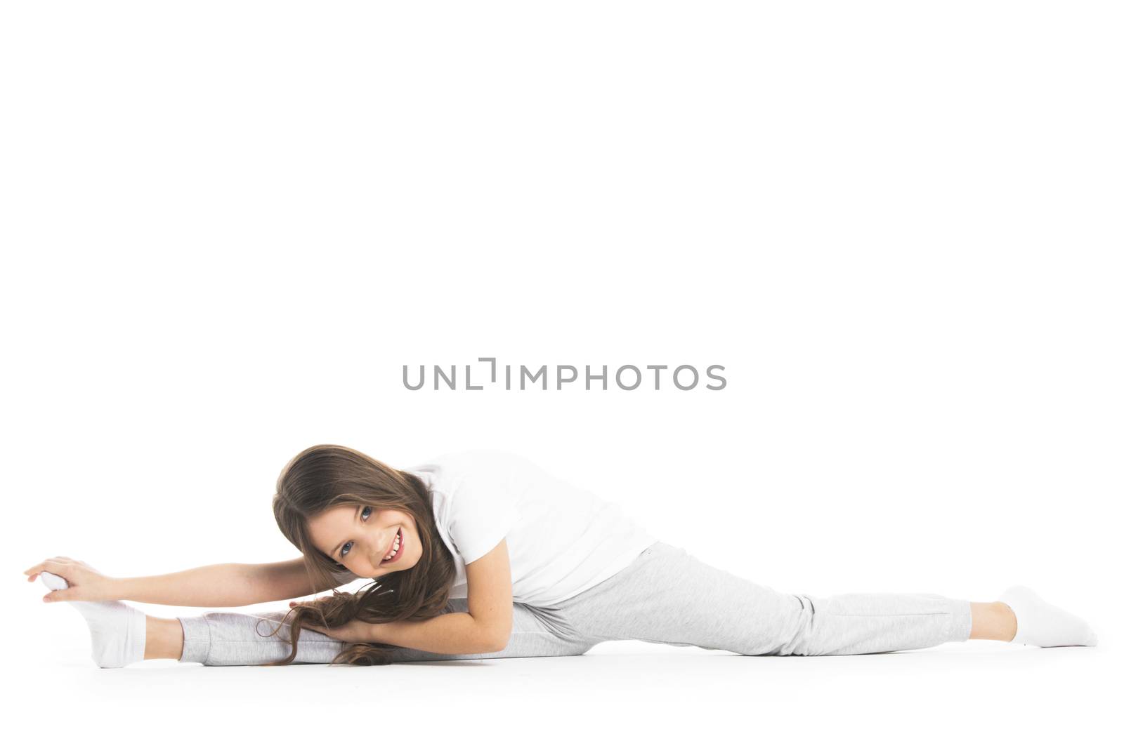 Girl doing split exercise isolated on white background