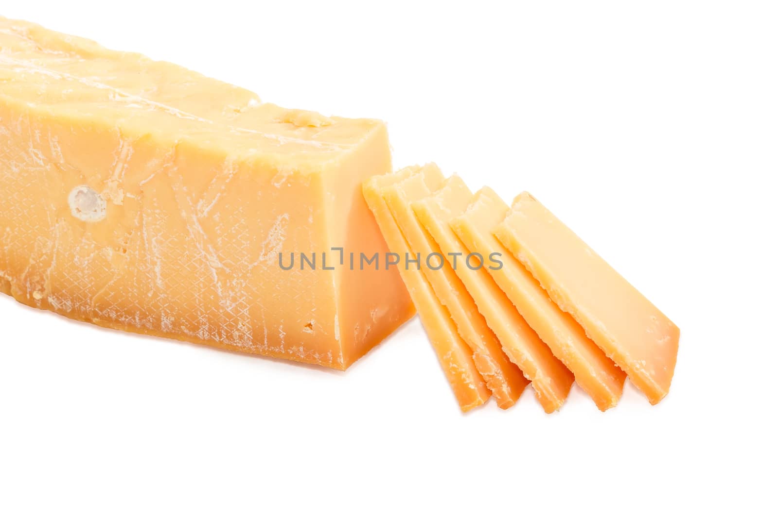 Several thin slices of the Dutch hard cheese Beemster on a dark glass saucer and piece of the same cheese beside on a light background
