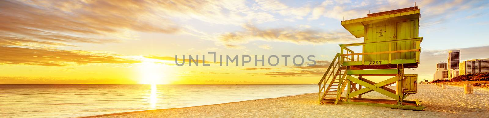 Miami South Beach sunrise with lifeguard tower and coastline with colorful cloud and blue sky. 