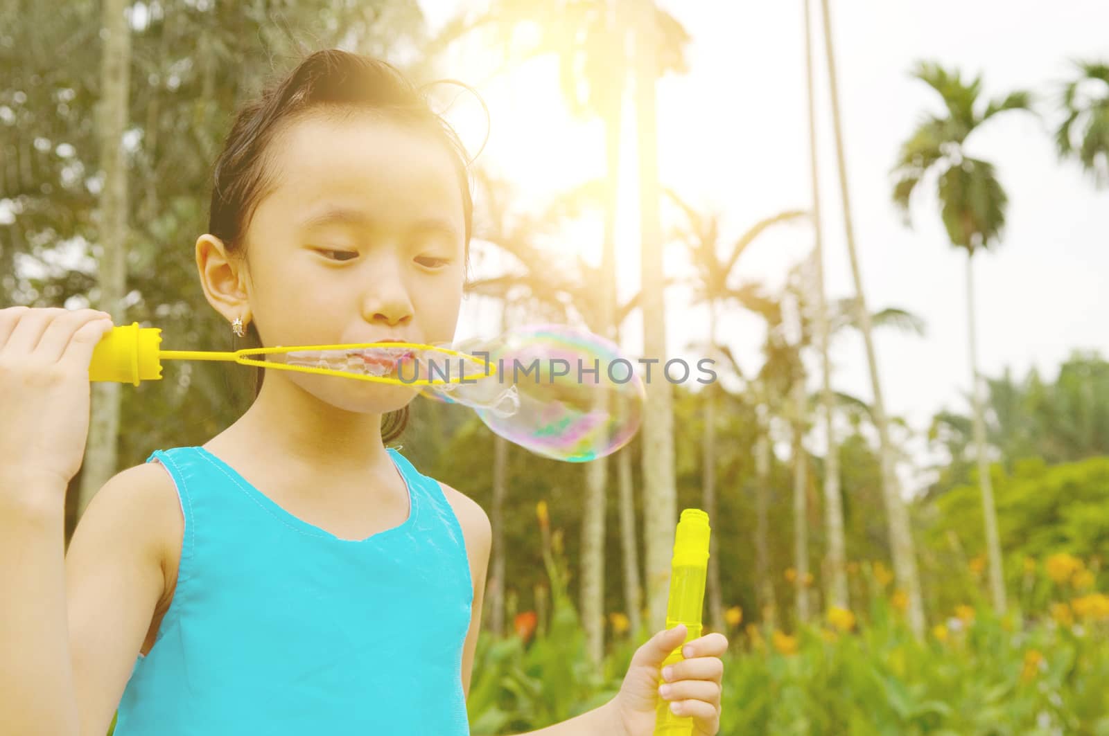 Asian girl blowing bubbles outdoor