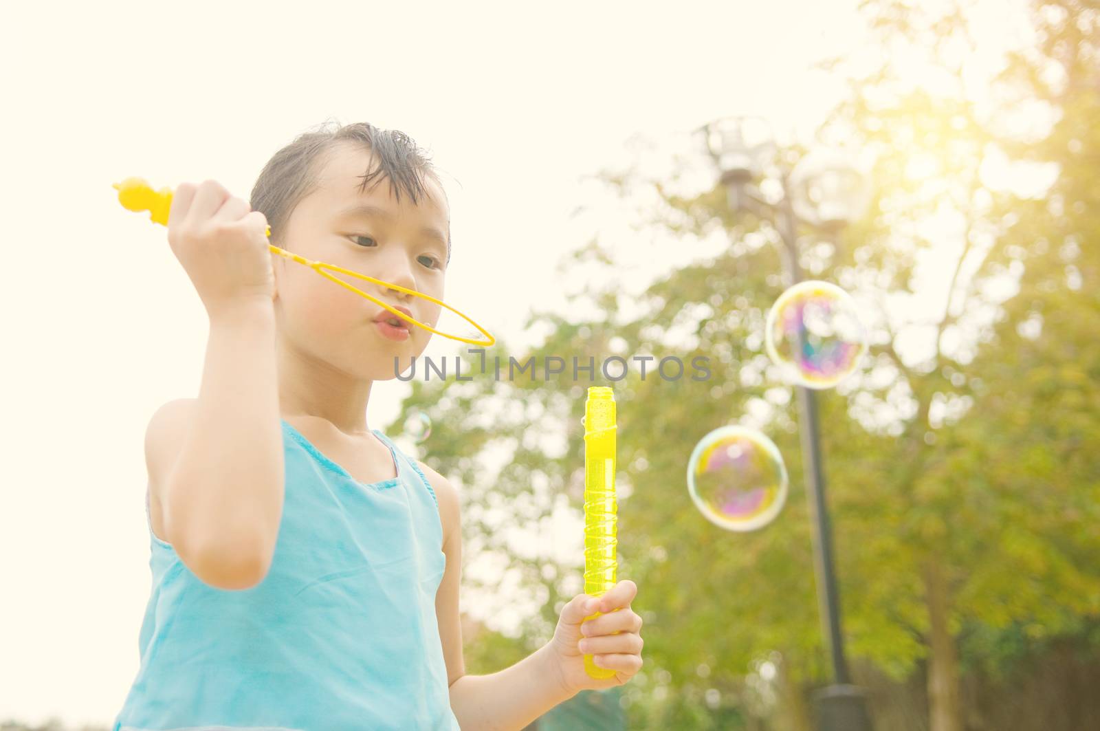 Asian girl blowing bubbles outdoor