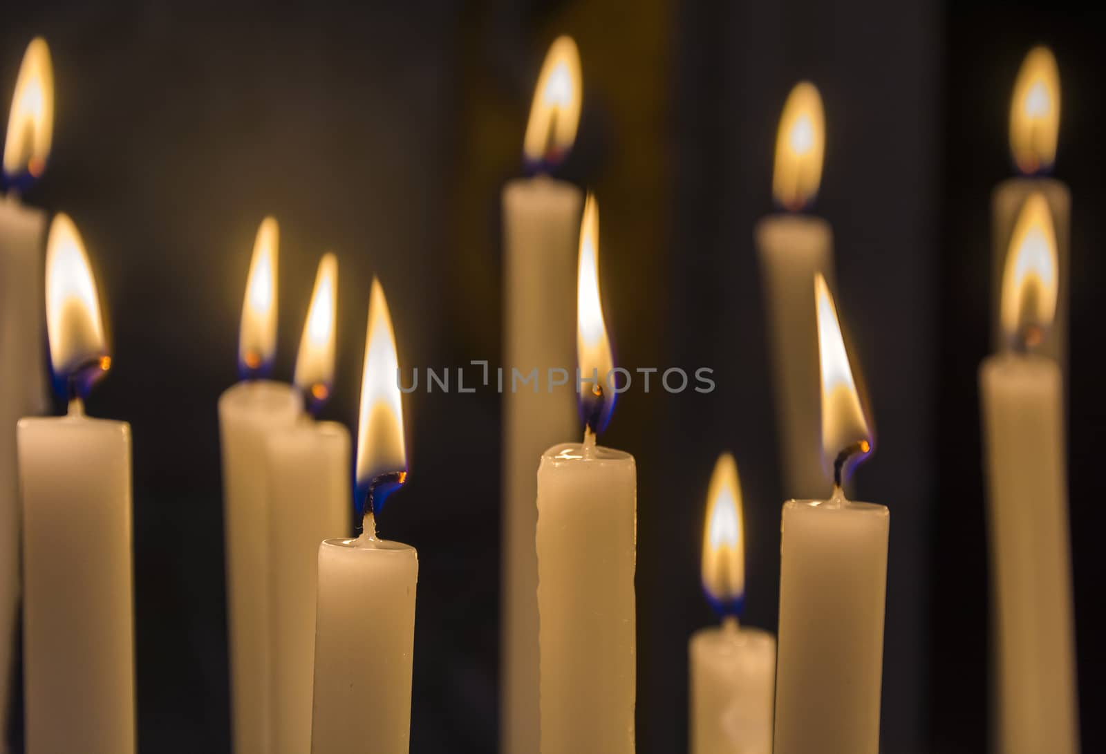 burning candles in catholic church on dark background closeup image