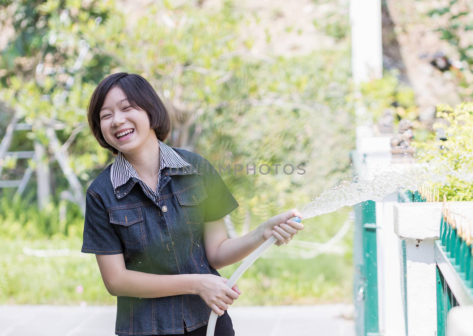 Women standing watering a tree by stoonn