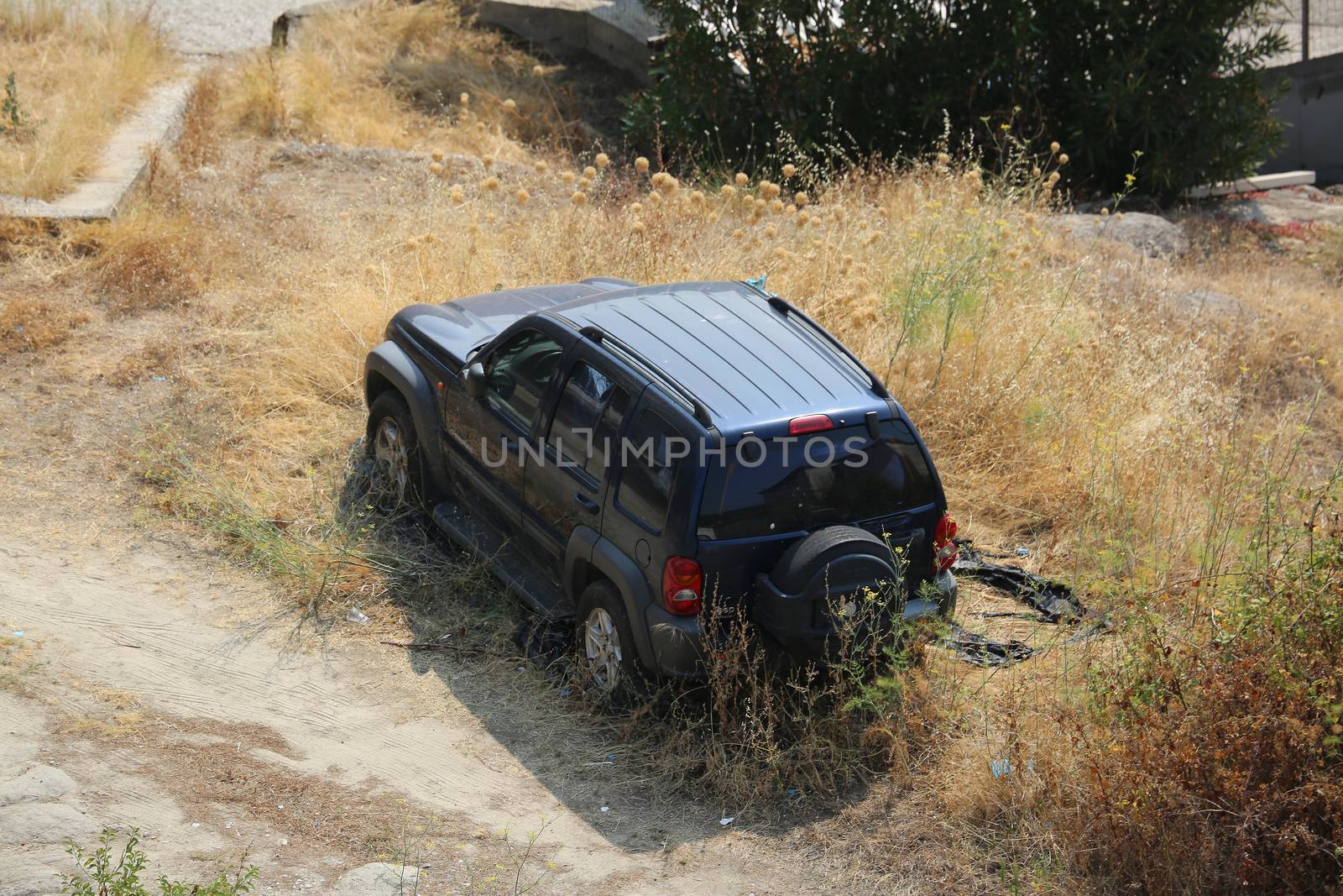 Kavala, Greece - August 2, 2016: Abandoned Beautiful Black Jeep Cherokee SUV in a Field in Kavala, Greece