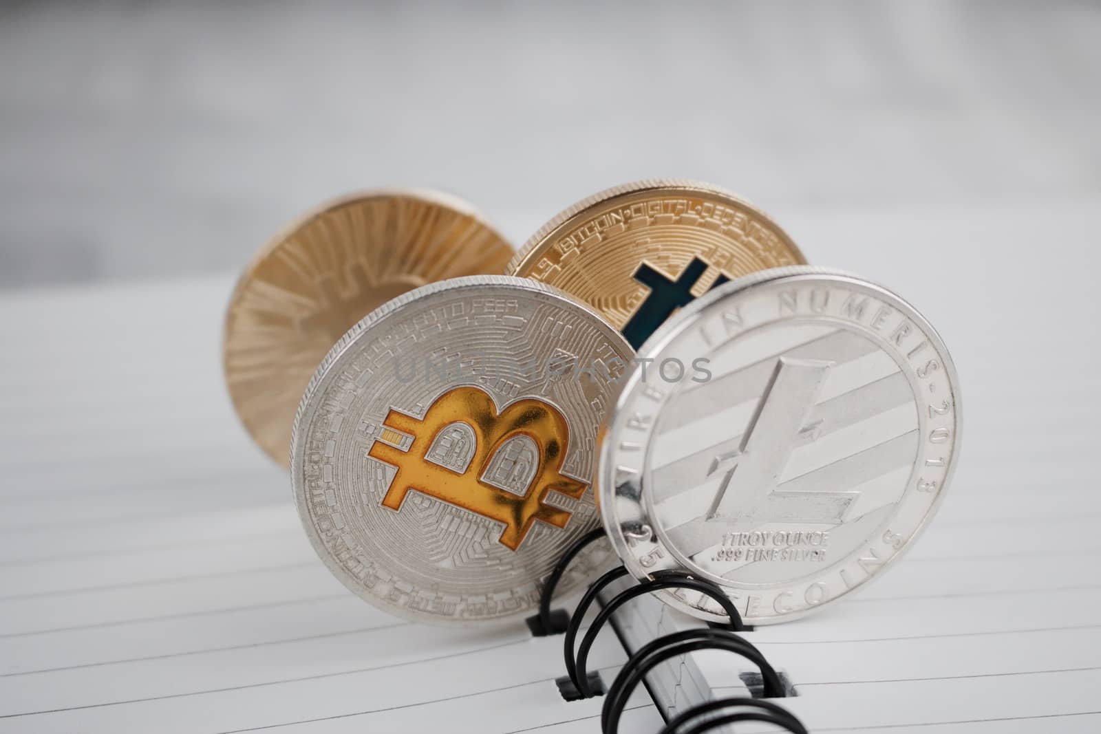 Digital currency physical silver and gold coins in notebook.