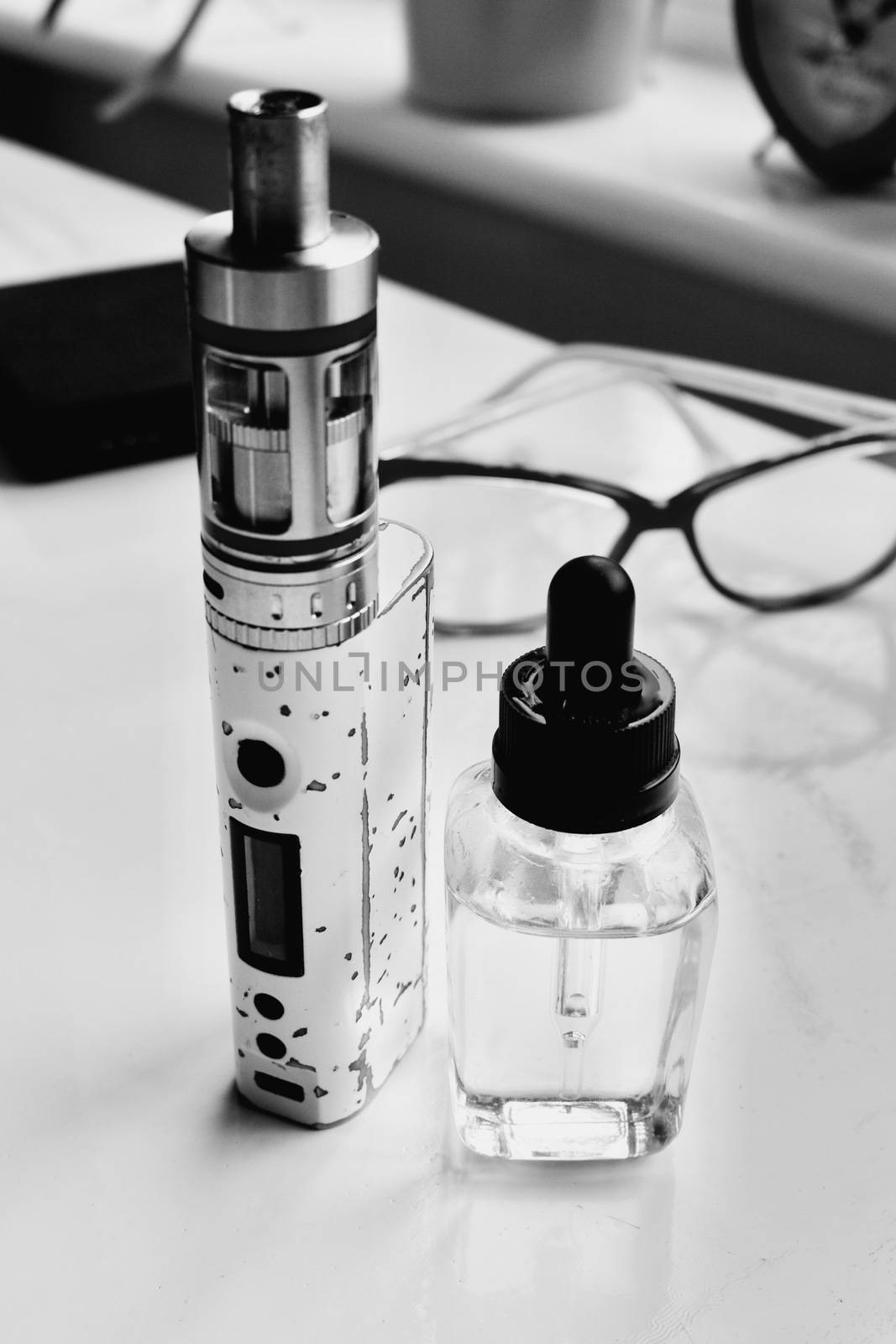 Old electronic cigarette with clear liquid on the table