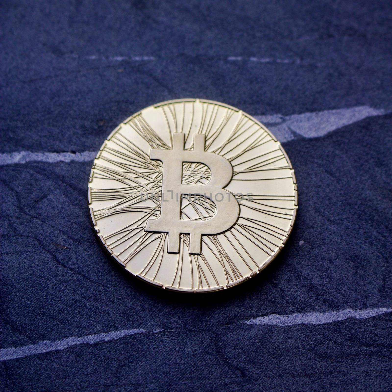 Bitcoin physical coin on a blue pattern