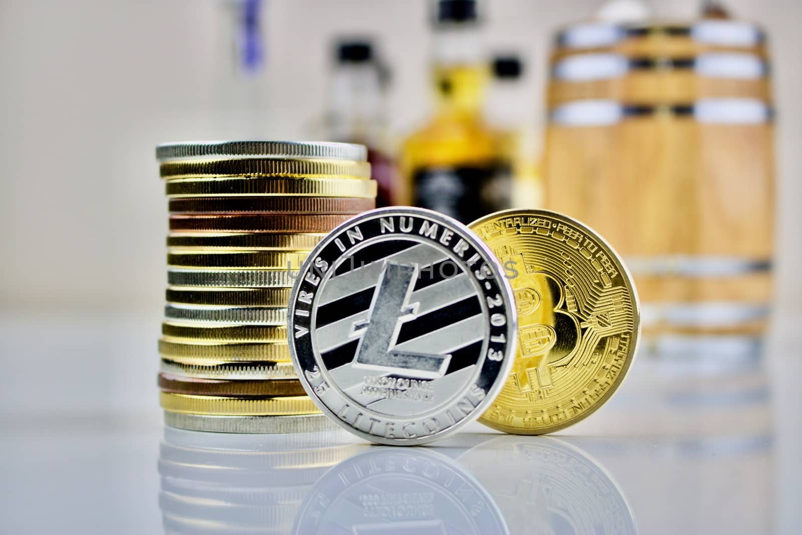 Cryptocurrency physical coins near a barrel