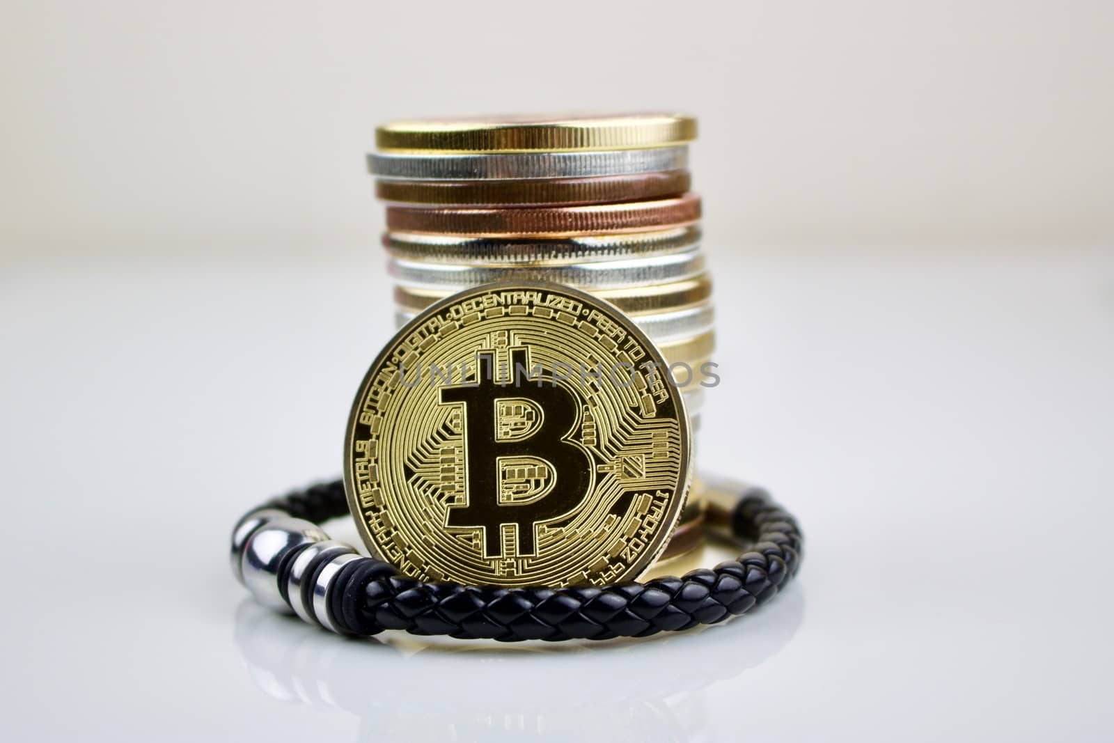Cryptocurrency physical coin and mans bracelet