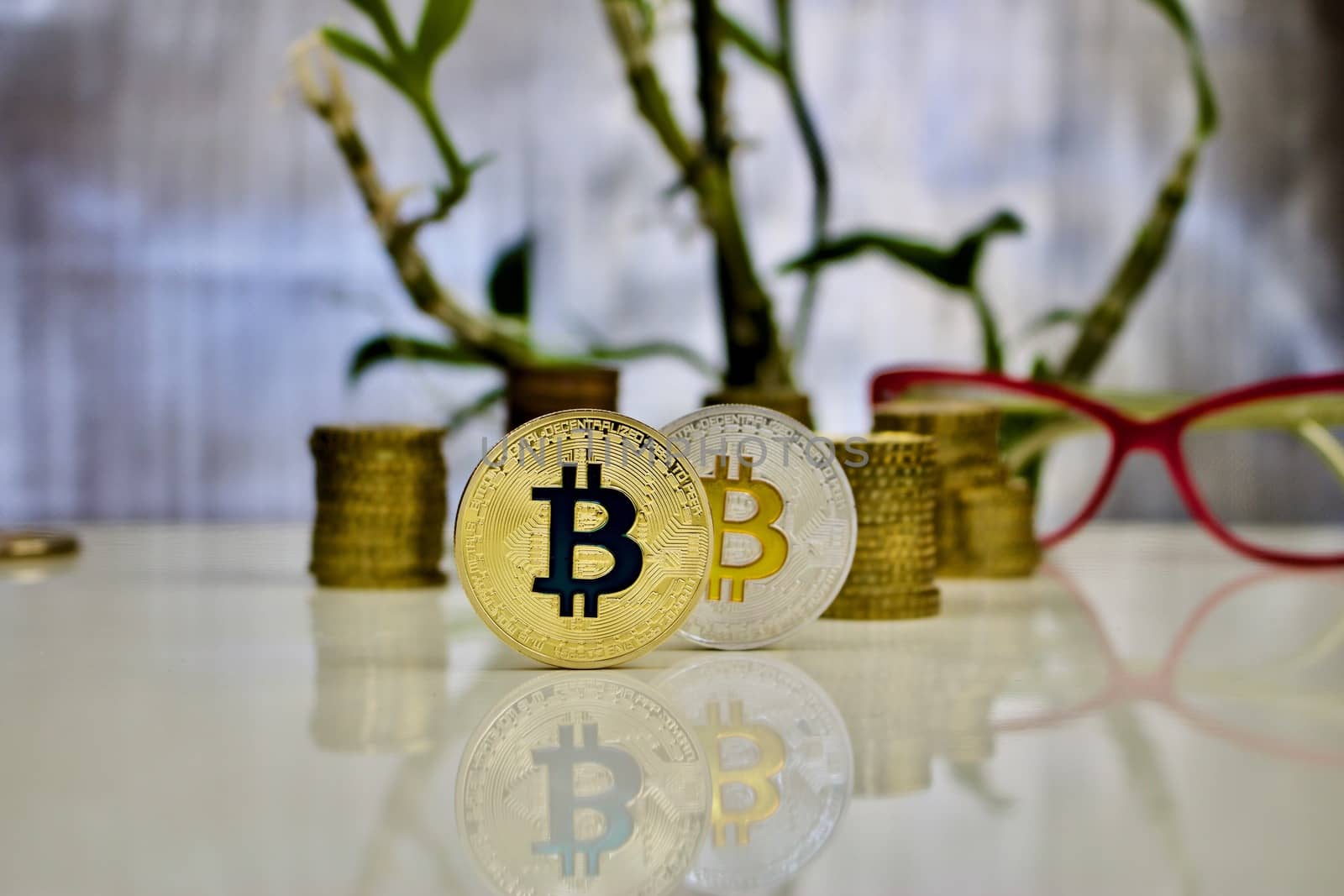 Digital currency physical gold and silver bitcoin coins near pink glasses