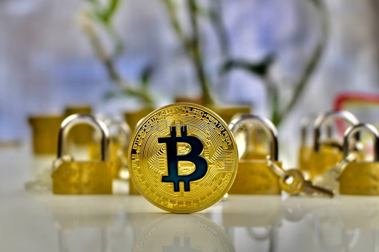 Cryptocurrency physical gold bitcoin coin near gold padlocks