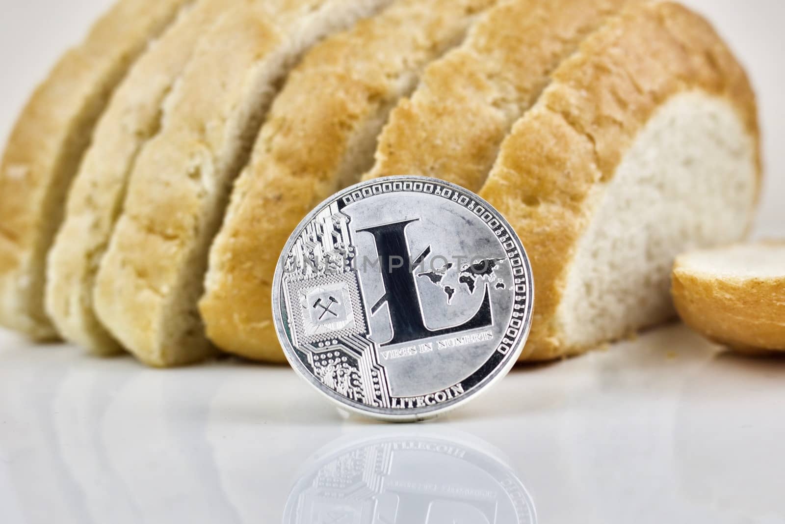 Physical silver cryptocurrency coin and fresh bread